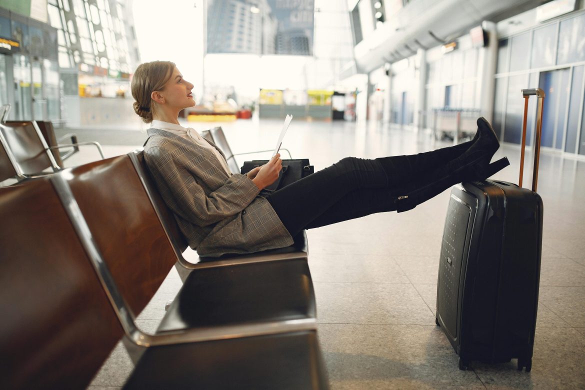 Femme assise sur une chaise à l'intérieur d'un aéroport